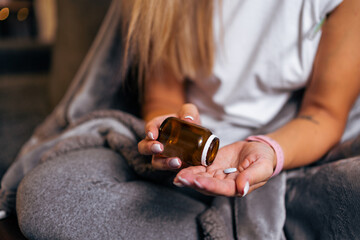 close up woman hand holding a medicine, with pours the pills out of the medicine bottle. Stop drug use Taking Medication Caring for the health care medical concept.