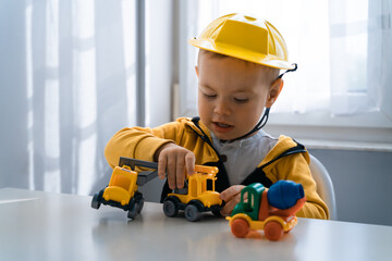 Child play with construction machinery at home, dreams to be an engineer. Little builder....