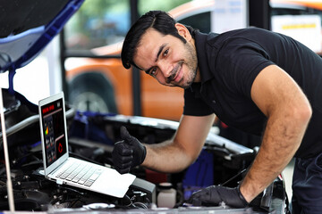 Fototapeta na wymiar Car mechanic working with a notebook in Auto Repair Service checking car engine.