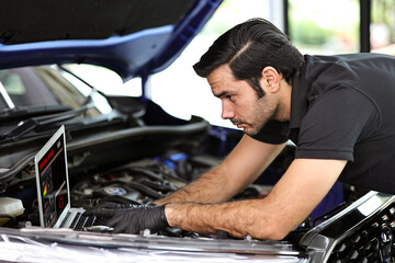 Fototapeta na wymiar Car mechanic working with a notebook in Auto Repair Service checking car engine.