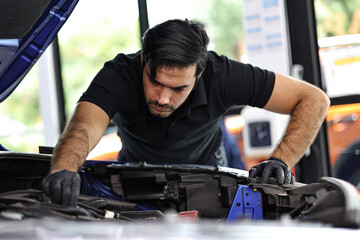 Professional mechanic working on the engine of the car in the garage. Car repair service.	