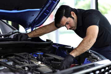 Fototapeta na wymiar Professional mechanic working on the engine of the car in the garage. Car repair service. 