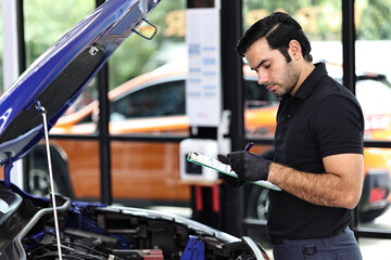 Fototapeta premium Car mechanic working with a Service checking car engine 