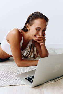 Woman working at home with laptop freelancer working at home trading online lying on the floor and smiling with teeth