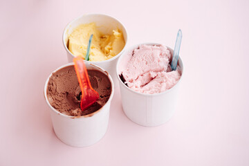 Set of bowls with various colorful Ice Cream with different flavors and fresh ingredients on pink...