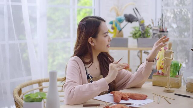 Young Asian girl making a sculpture with modeling clay at home .hobby clay sculpt concept