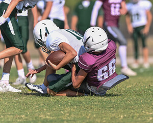Young athletic tackle football player making a tackle during a game