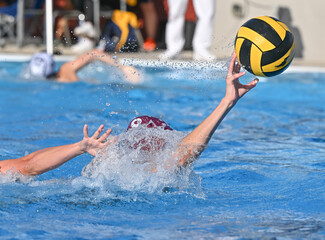 Young teen girls playing a competitive game of waterpolo