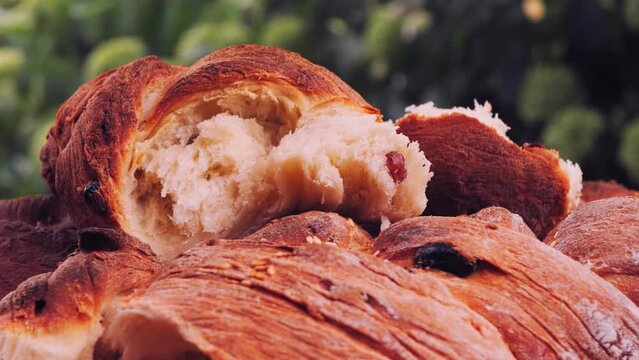 Shabbat challah bread with sesame seeds and raisins rotates in a circle on a wooden table. Close-up