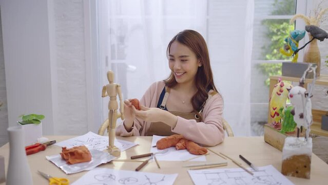 Young Asian girl making a sculpture with modeling clay at home .hobby clay sculpt concept