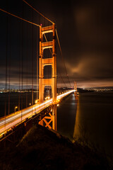 Golden Gate Bridge at night with long exposure traffic headlight streaks in vertical orientation;...