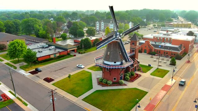 Old fashioned dutch windmill rotating in the wind, moving aerial view.
