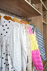 Open space minimalistic scandinavian white wood walk in closet and wardrobe in neutral beige colors