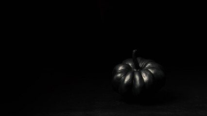 Halloween black pumpkins on a dark background. Creepy holiday decor. Painted pumpkin.