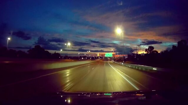 Night driving highway with street lights and dramatic sky, dash camera look and feel.
