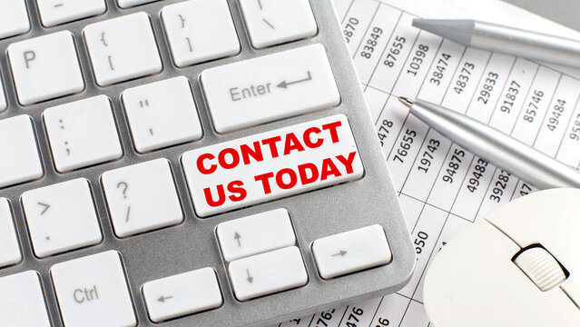 CONTACT US TODAY text on a keyboard wirh chart and pencil