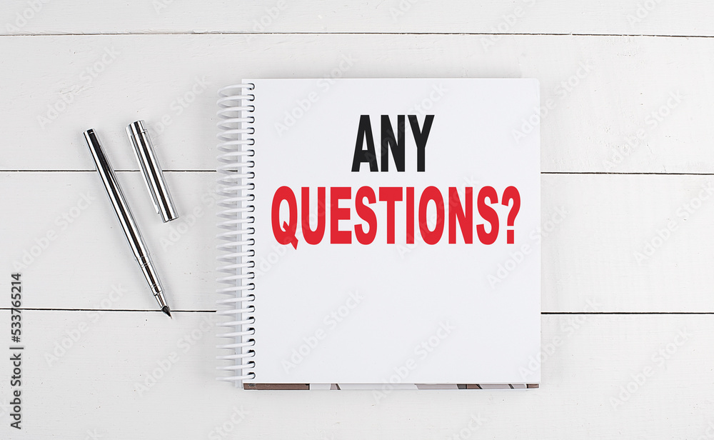 Aufkleber any questions text written on notebook on the wooden background