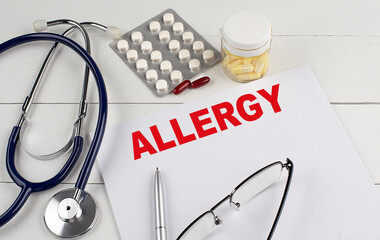 ALLERGY word on paper with stethoscope and pills