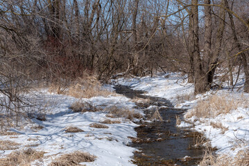 Small Creek Thawing In April Snow