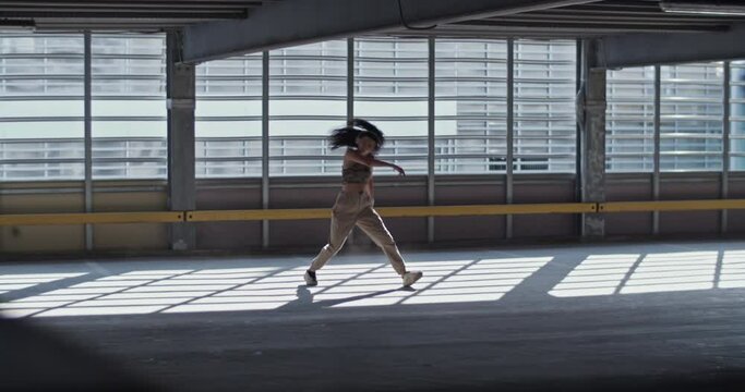 Young woman dancing in empty parking building