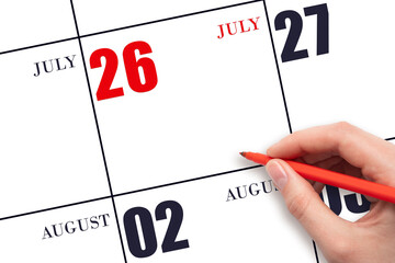 A hand holding a red pen and pointing on the calendar date July 26. Red calendar date, copy space,...