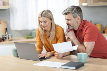 Husband and wife working on family budget together at home - Powered by Adobe