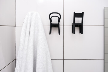 Clean white towel hanging on a hook in a bathroom close up