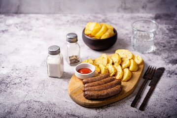 Fried sausages with roasted potato slices