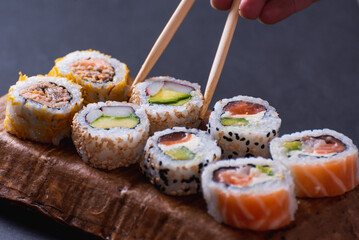 close up of chopsticks taking sushi out of a tray