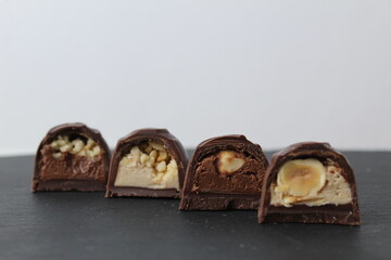 four chocolate case candies with hazelnuts peanut praline chocolate close-up on a gray background with space for copyspace text