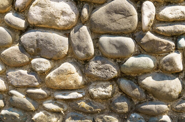 The texture of the wall of brown stone masonry.