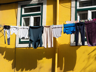 Lissabon - Stadtteil Mouraria: W&auml;sche zum Trocknen an gelber Hausfassade