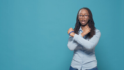 Woman doing stop rejection gesture with arms, standing over blue background in studio. Showing...