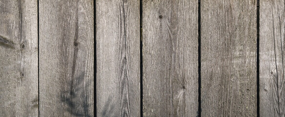 Naklejka premium Wooden texture with horizontal lines. The texture of wood with knots and holes. The background of a wooden fence damaged by time. Banner of an old wooden fence.