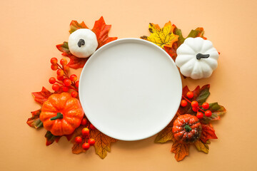 Autumn table setting. White plate, golden cutlery and fall decorations. Flat lay image with copy...