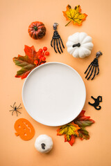 Halloween food concept. White plate, cobweb, hands, spiders, pumpkins. Flat lay image with copy space.