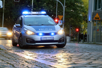 Radiowóz polska policja z  Sygnalizator błyskowy niebieski na dachu radiowozu.  Alarmowo wieczorem.  © FotoDax