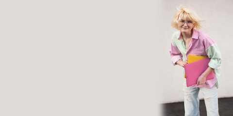 Funny teenage girl student with folders on the neutral background,large banner.