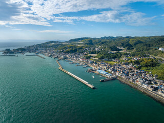 Fototapeta premium Aerial view of calm sea and breakwater protecting small coastal town