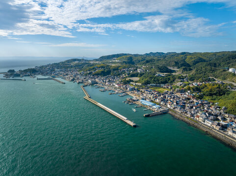 Aerial view of calm sea and breakwater protecting small coastal town