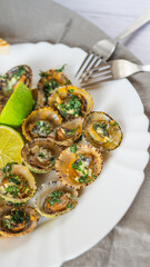 Patella, Limpets with lime on white plate - traditional seafood of Tenerife and Madeira Islands.