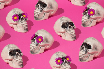 Creative pattern with Skull and pink flower against pink background. Halloween fashion idea. Santa...