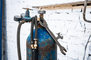 Old gas cylinders for welding and cutting. Rusty propane and oxygen tanks. Tools for metalworking...