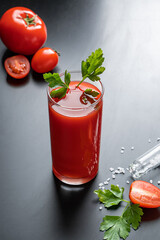 Delicious tomato juice on a black background. Vegetable drink for vegan and healthy eating.