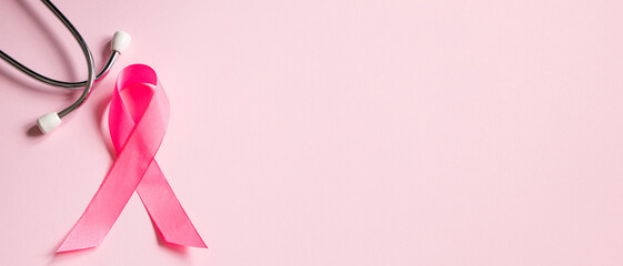 Breast Cancer Awareness Month. Pink ribbon and stethoscope on colored background. Women's health...