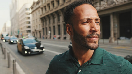 Close up, young man walks down the street, looks around