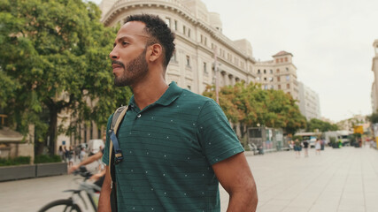 Young man tourist walks along the square of the old city, considers the sights