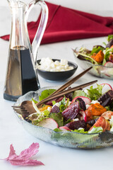 Plates of roasted beet and carrot salad with feta, ready for eating.
