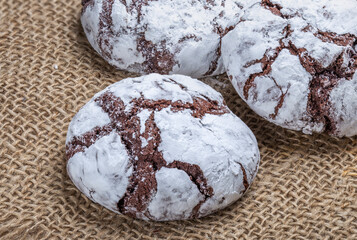 Cracked chocolate chip cookies sprinkled with white powder.