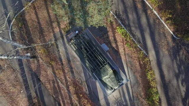 An old military car stands on a concrete pedestal. Military rocket technology. the camera shoots from the air smoothly moves away